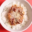 Garlic Parmesan chicken thigh fillet on top of steamed rice.